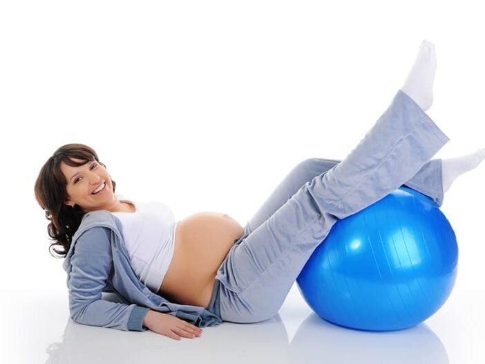 Mulher grávida fazendo exercícios físicos na bola